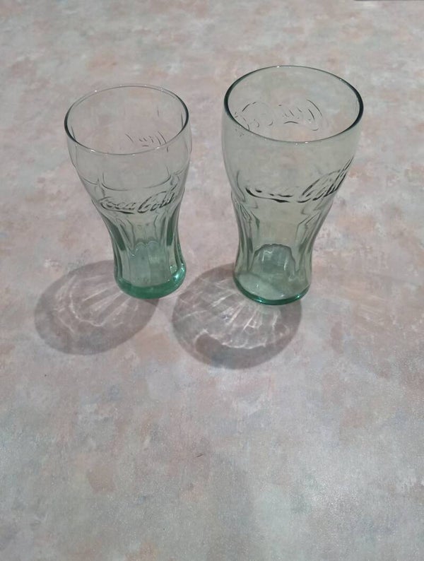 Two different size embossed green tinted Coca Cola Glasses. One is stamped 1961. Uk Postage Only.