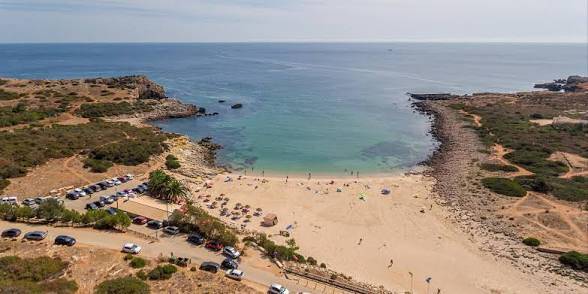 Sheltered sandy bay surrounded by cliffs at Praia da Ingrina near Raposeira.