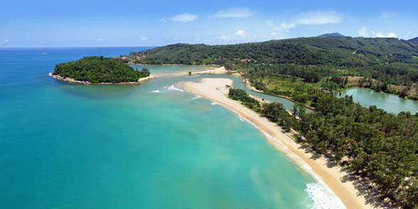 Aerial view of Layan Beach in Phuket, with turquoise water, a sandy shoreline and wooded hills.