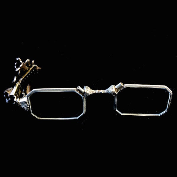 Antique lorgnette folding glasses with stylised lily flowers and foliage.