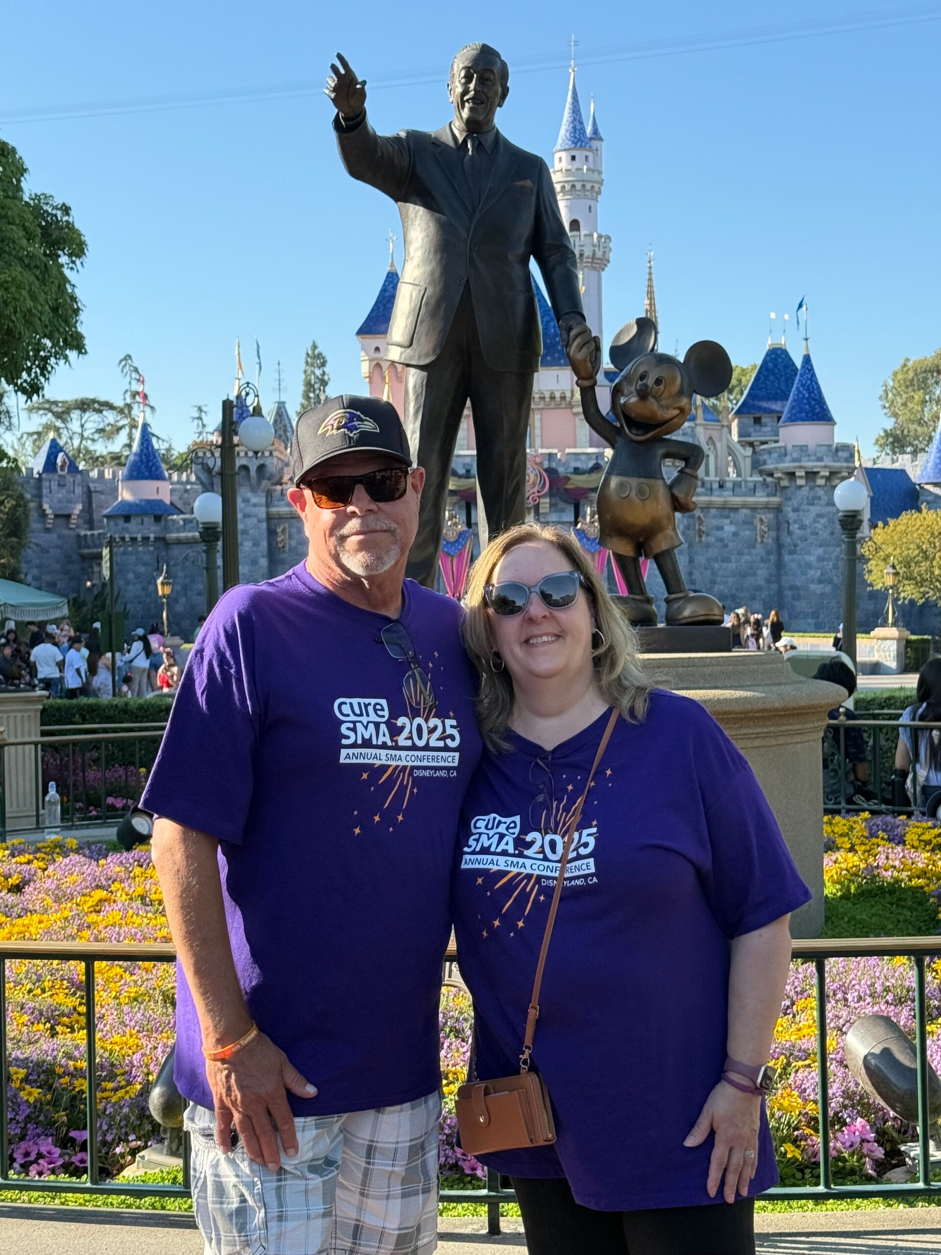 Jeff Selby and his wife Angie wearing Cure SMA Conference shirts at Disneyland.
