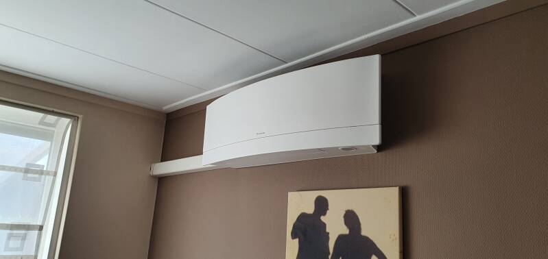 Daikin Emura design wit binnendeel tegen een bruine muur
