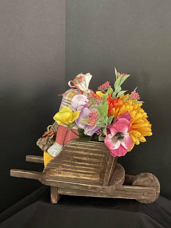 girl gnome for fall or spring in wheel barrel