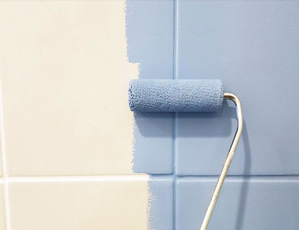 piastrelle bianche con rullo che le vernicia di indaco
