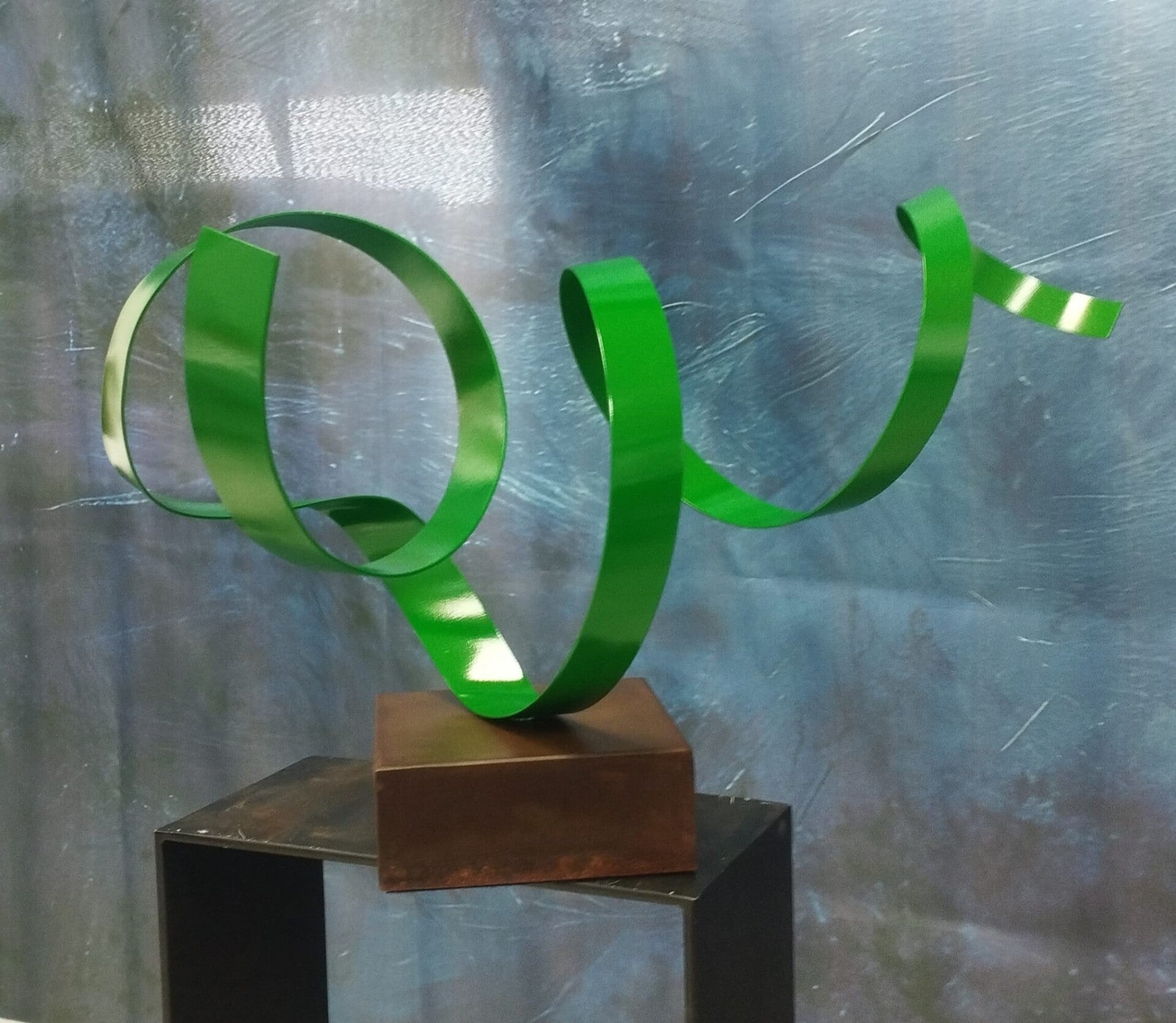 Escultura de metal rojo 'Ascenso Escarlata', dos tubos verticales cruzados con chapas en espiral ascendentes