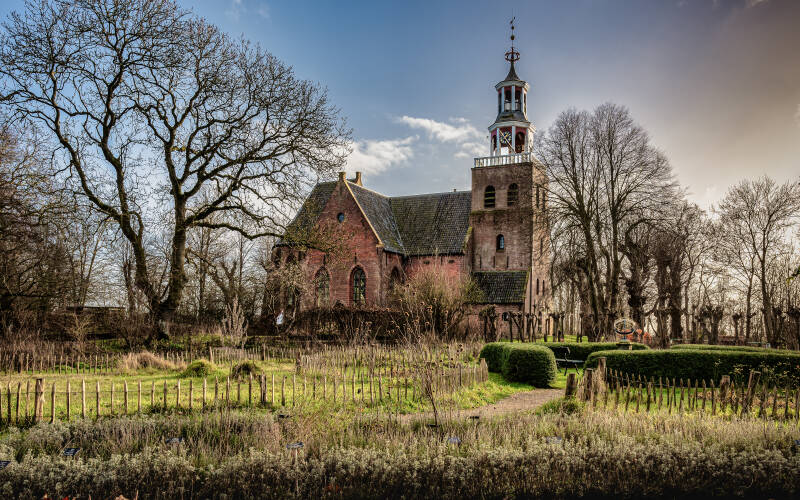 Monumentale Petruskerk in Pieterburen gefotografeerd vanuit de botanische tuin, erfgoed en architectuur in Groningen.