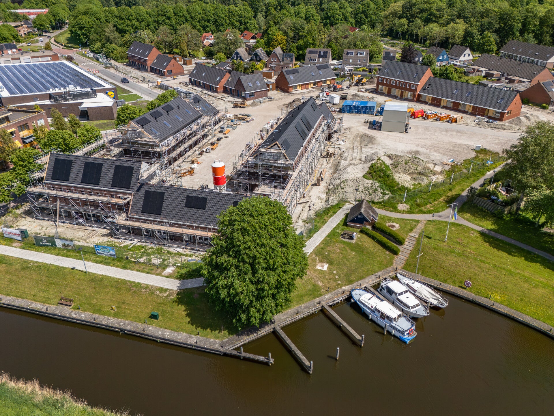 Dronefoto van nieuwbouwproject in Groningen met woningen in aanbouw en gebiedsontwikkeling vanuit de lucht.