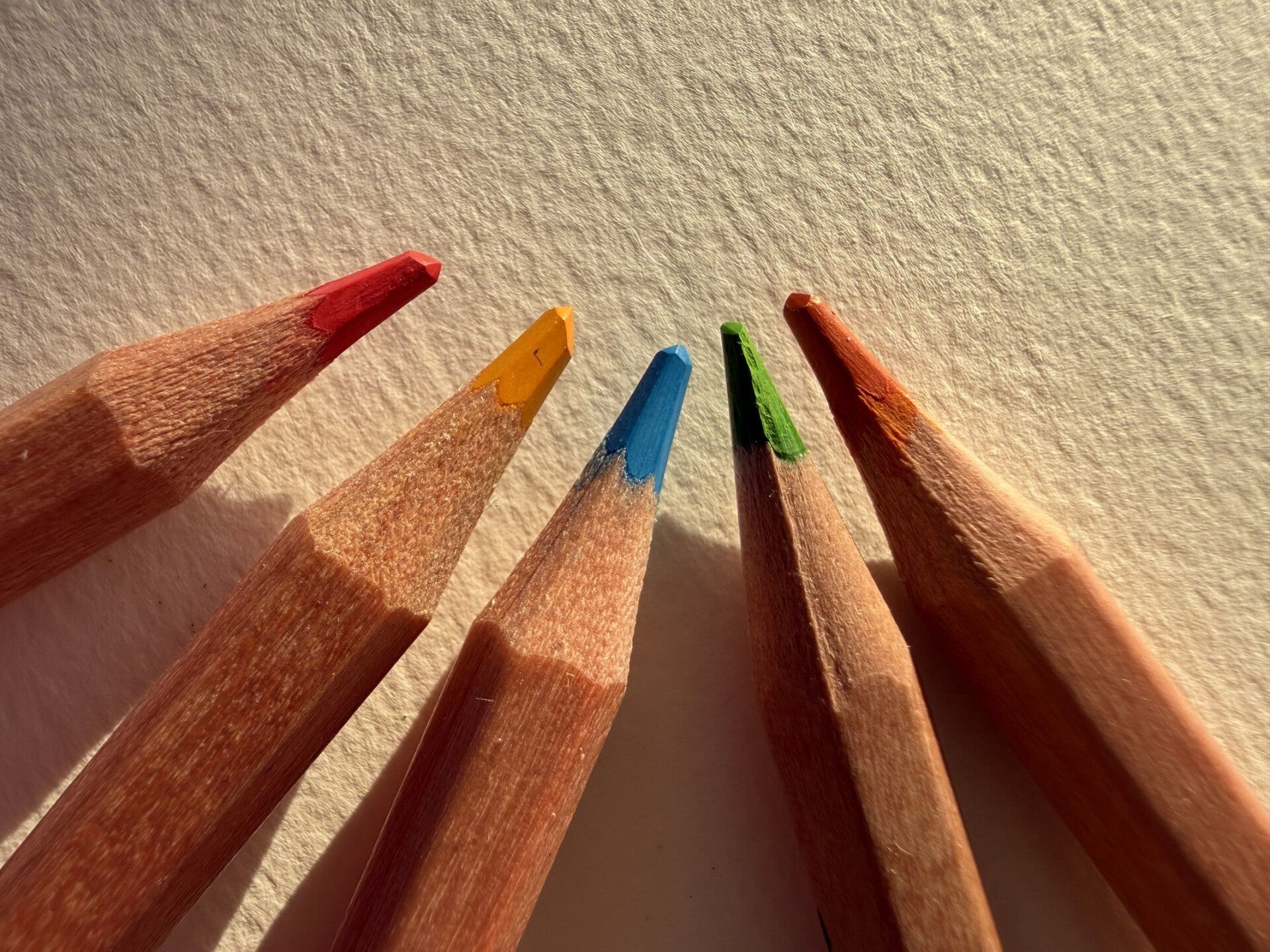 Spiten von Farbstiften in Nahaufnahme. Von Links nach rechts: Rot, Gelb, Blau, Grün, Orange.