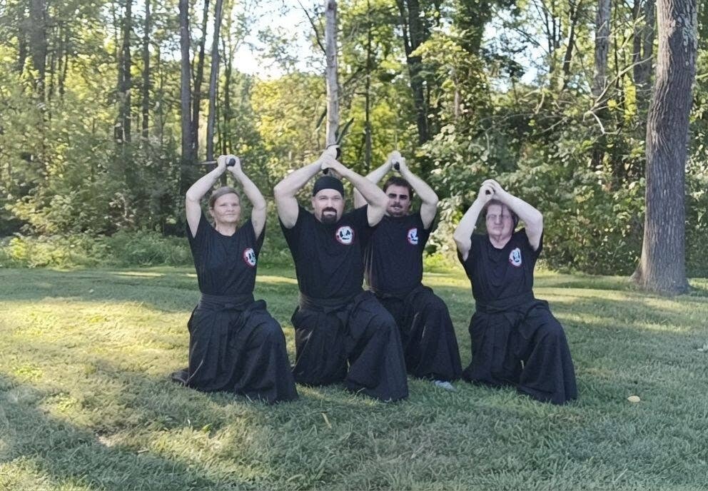Ninja Bob Calvert of the Black Scorpion Ninjutsu Society leading an outdoor training session with students in the park.
