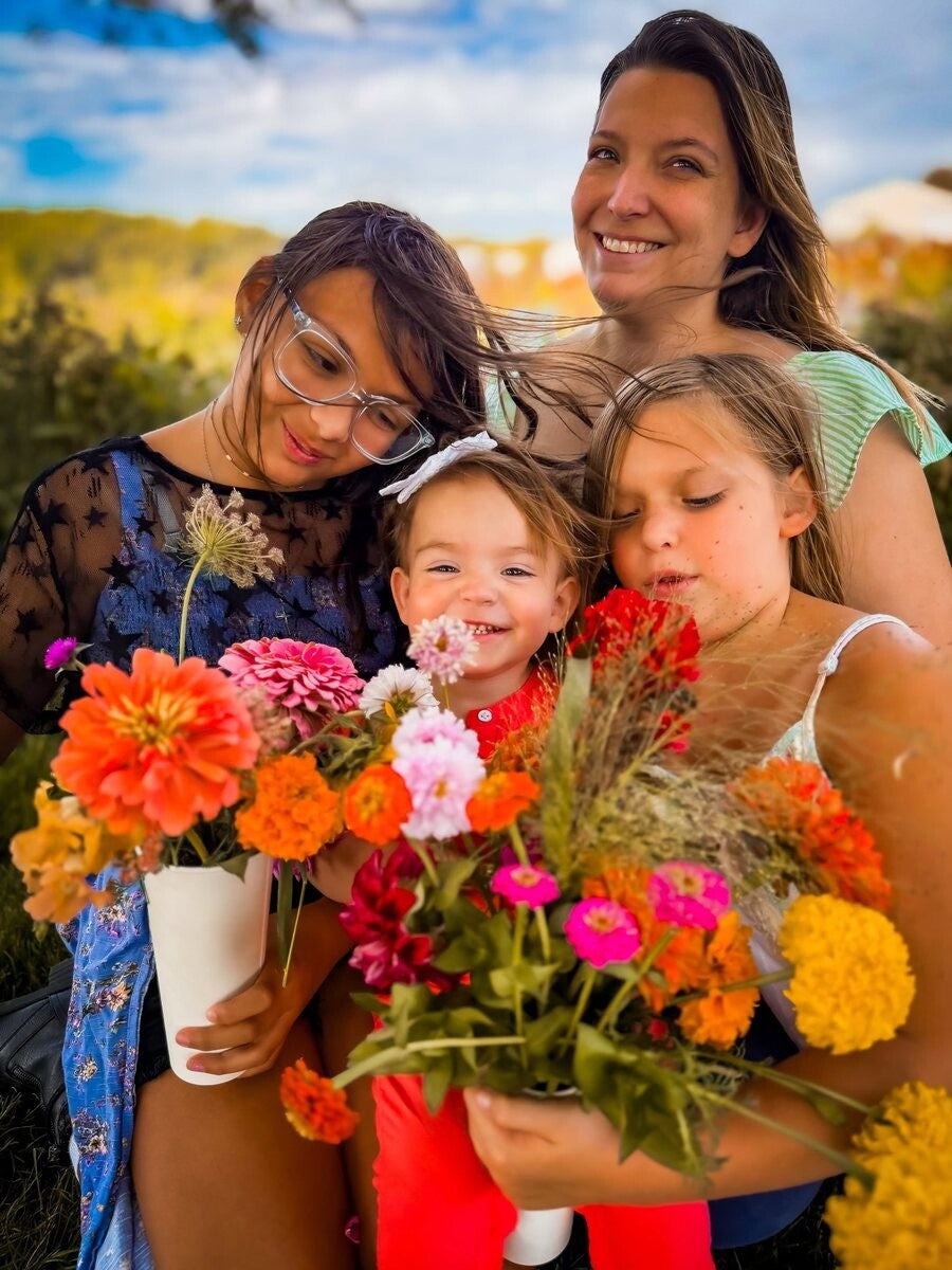 The girls holding colorful zinnia bouquets