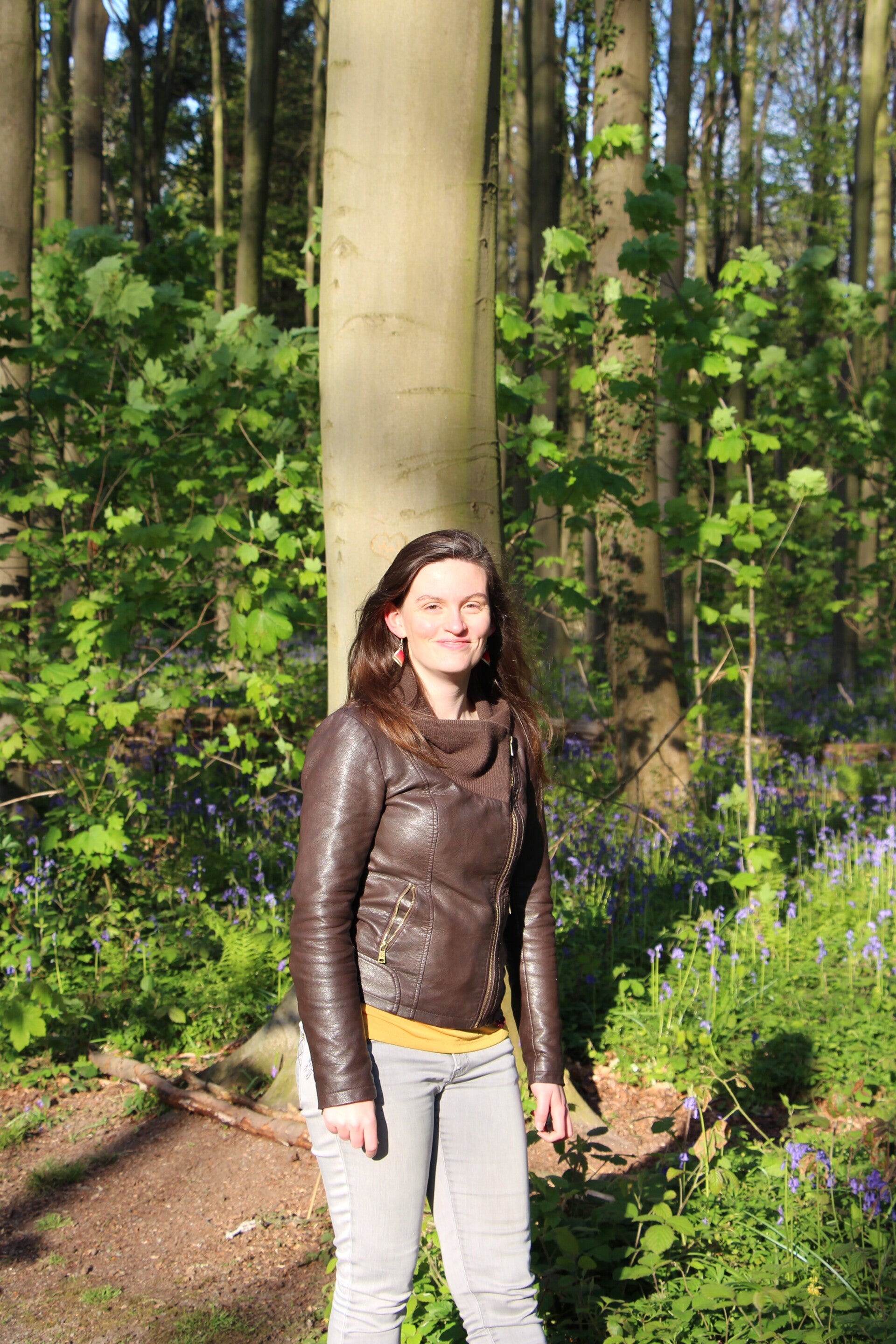 Freya psycholoog, psychotherapeut en mamacoach in regio Kapellen, Brasschaat in de natuur met blauwe bloemen op de achtergrond