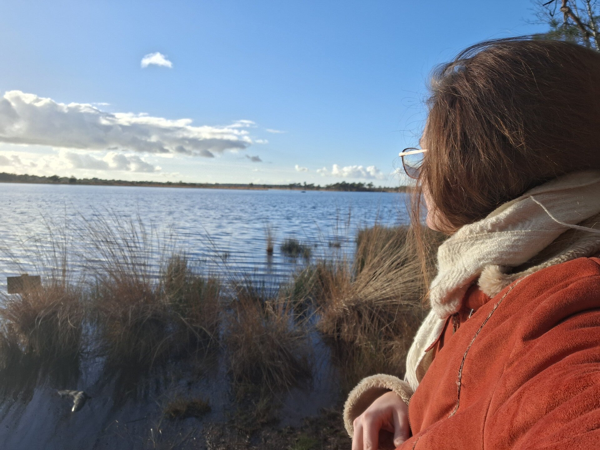 Freya psycholoog en psychotherapeut kijkt over een meer in de natuur regio Kapellen Brasschaat en Kalmthout.