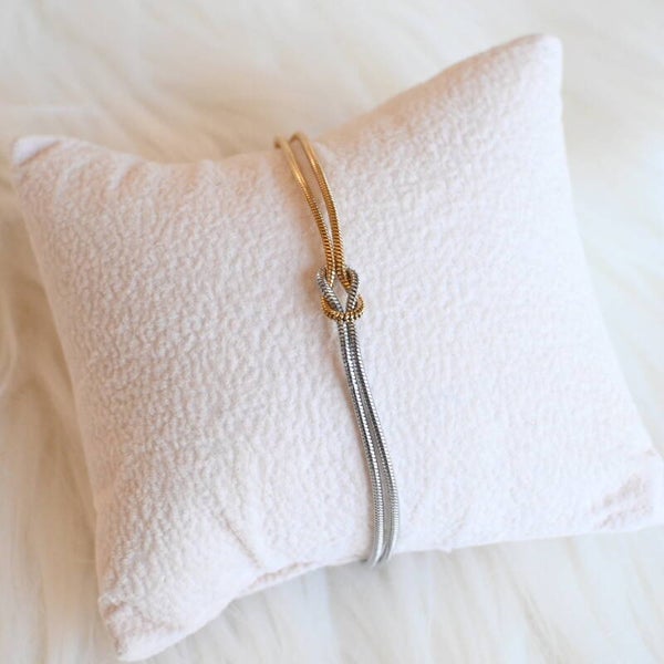 Fijne zilver -en goudkleurige armband met knoop
