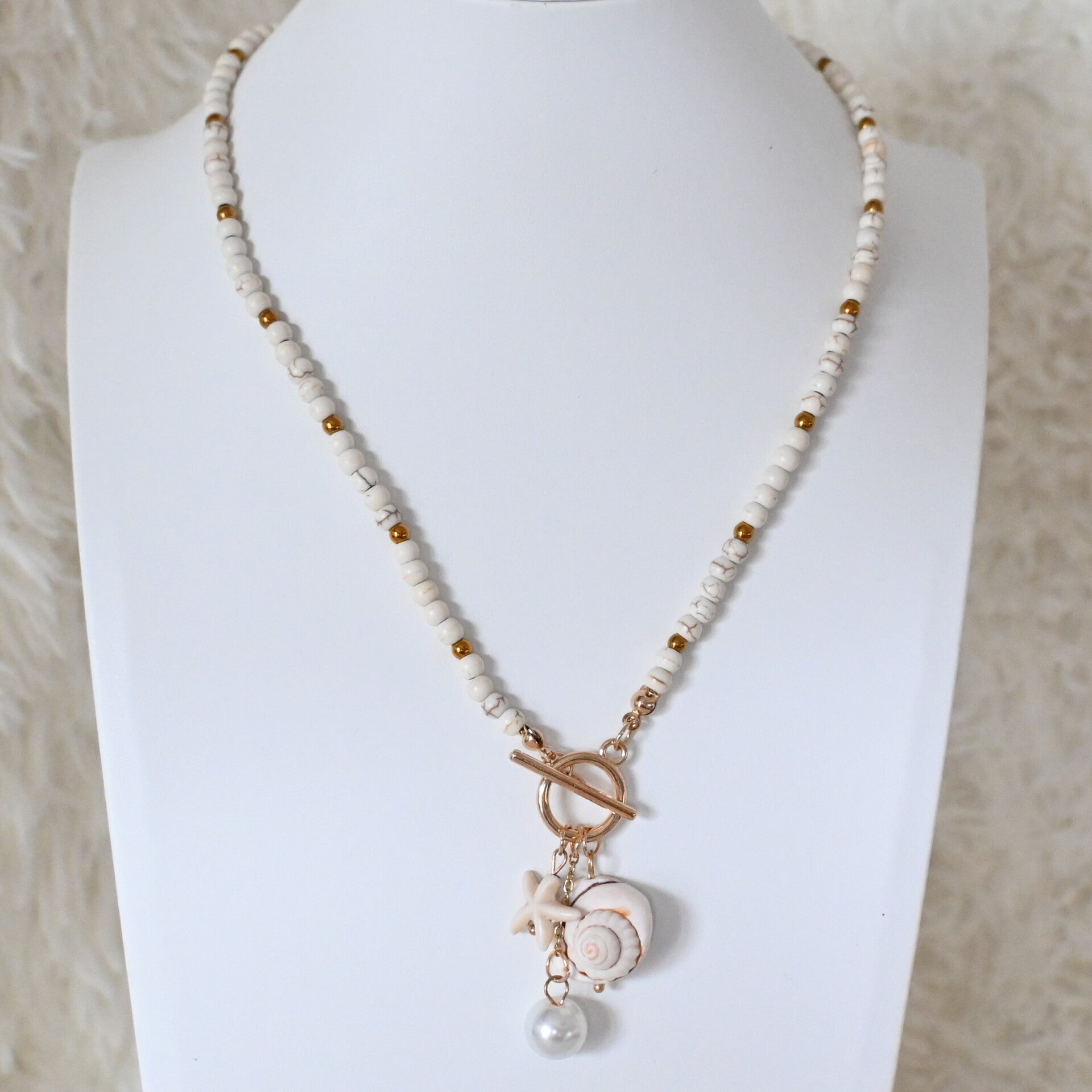 Trendy beige bedelketting met schelp