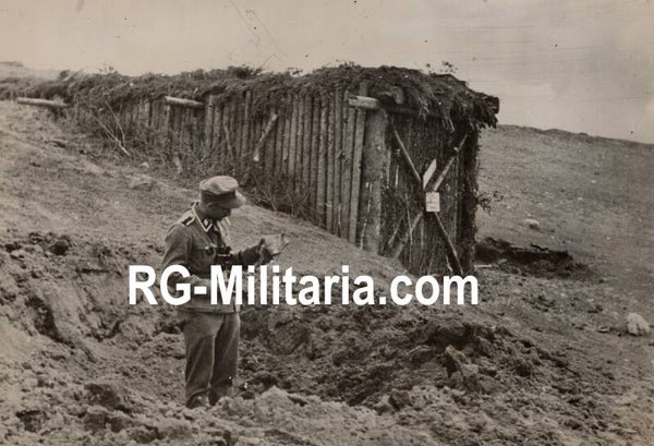 Original WW2 German Waffen SS Press Photo - SS soldier looking at an artillery crater next to the front cinema (1942)