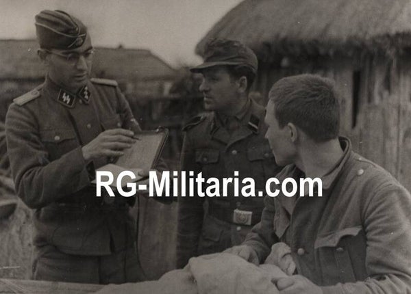 Original WW2 German Waffen SS Press Photo - SS Wiking panzergrenadier questioning a Soviet partizan in German uniform (1943)