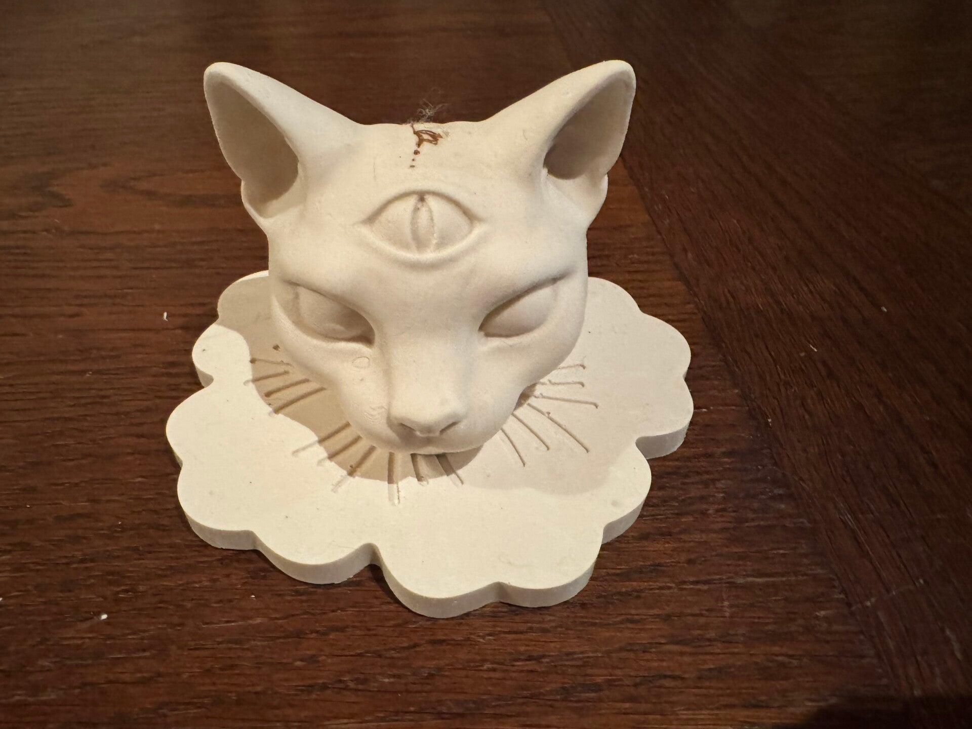 Tête de chat 3 oeils sur plateau floral .