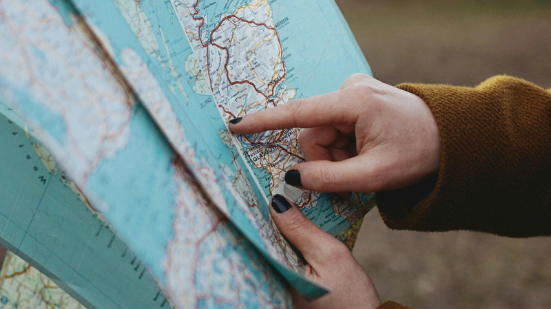 Jemand deutet mit seinen Fingern auf einen Punkt auf einer Landkarte. Wir sind so achtsamer, als wenn wir das Handy zur Navigation nutzen. (Foto: Beyzanur K.)