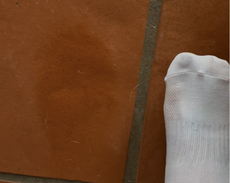 Soaked socks on kitchen floor barefoot model