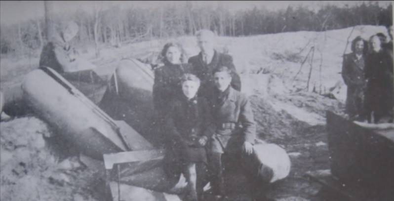 Een gezinsfoto ten midden van de restanten van de opgeblazen M.A.St., 1945.