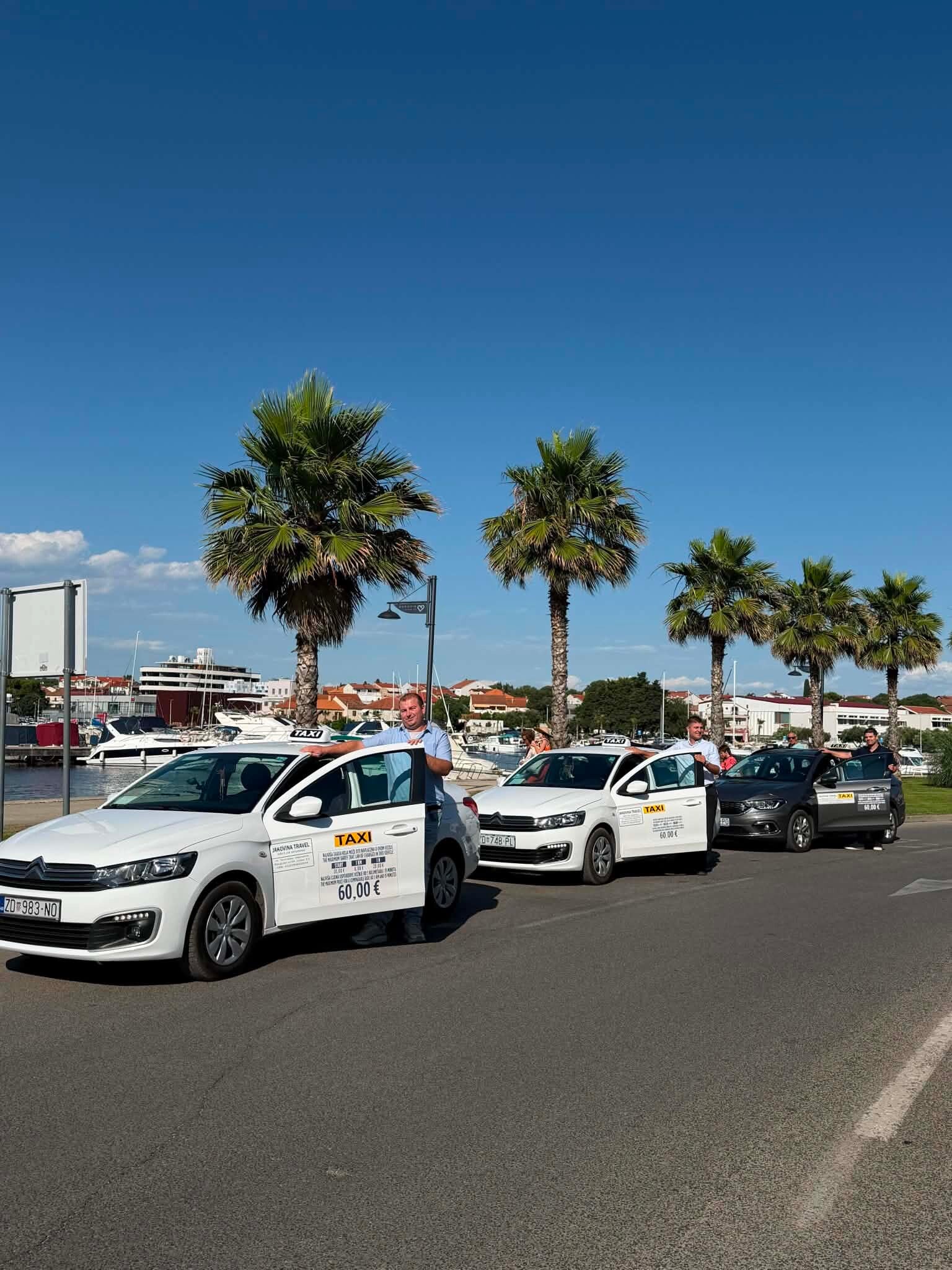Flota bijelih i crnih taksi vozila i profesionalni vozači Taxi Jakovina u Biogradu na Moru.