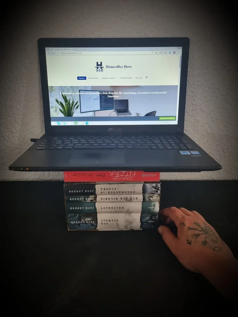 Laptop auf einem Bücherstapel als ergonomische Erhöhung