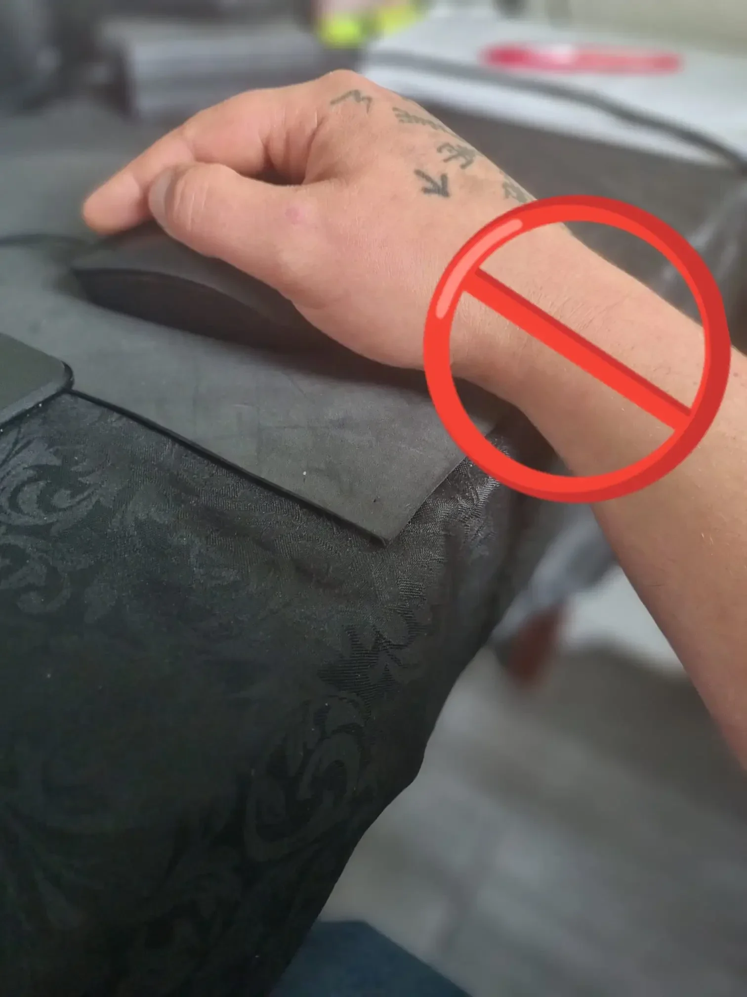 Ein an der Tischkante abgeknicktes Handgelenk und ein Verbotszeichen. Es ist eine Warnung das von so einer falschen Haltung ein Mausarm entstehen kann.