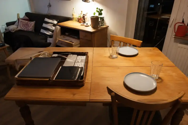 Laptop, Tastatur und Maus werden verstaut, während der Esstisch fürs Essen freigeräumt wird