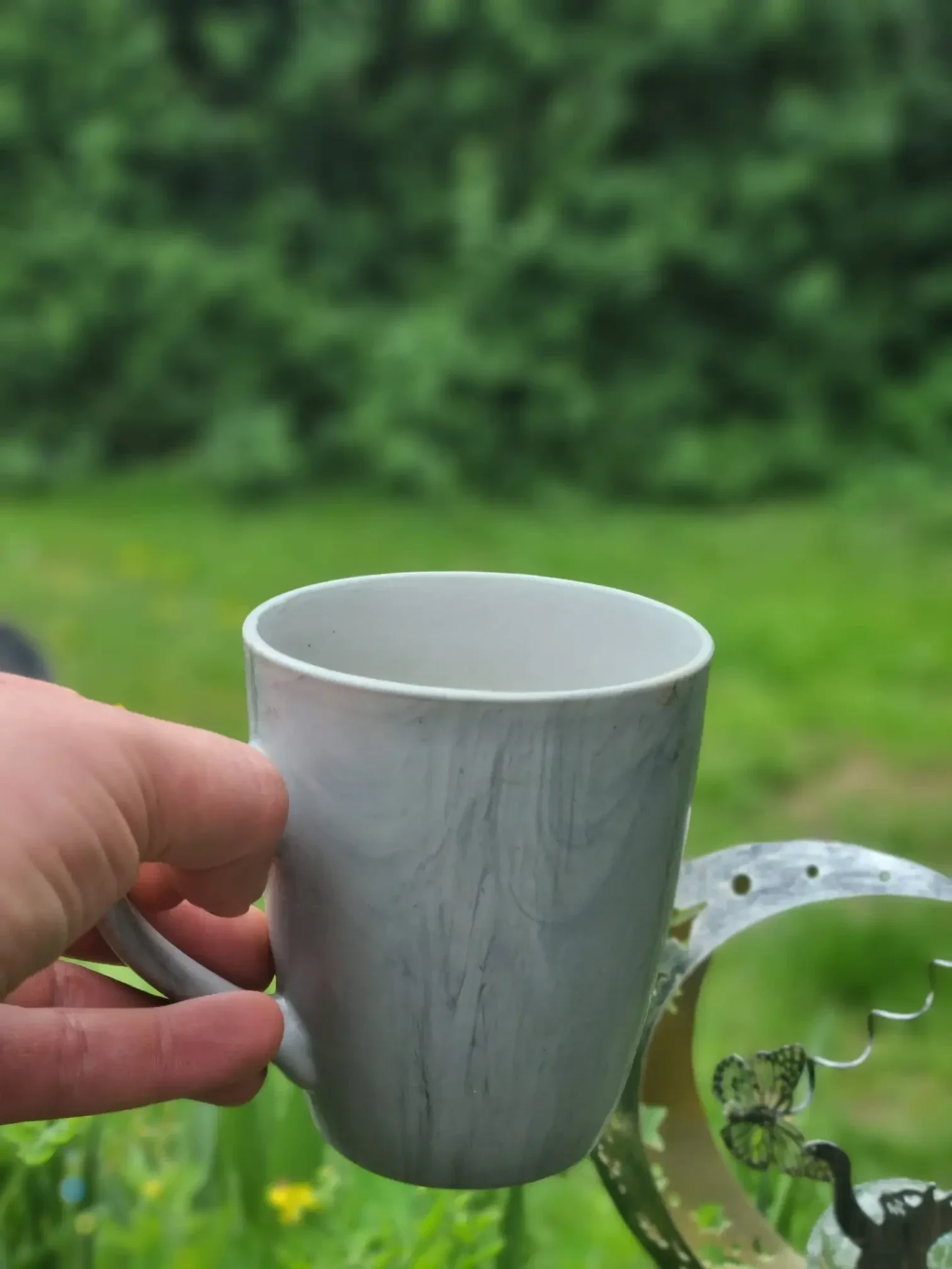 Entspannter Feierabend im Homeoffice: Eine Kaffeetasse steht im Garten und symbolisiert die bewusste Trennung zwischen Arbeit und Privatleben.