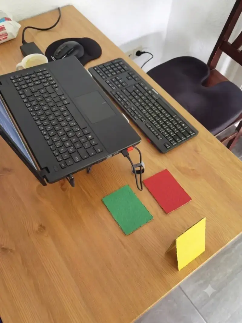 Selbst gebastelte rote, gelbe und grüne Signalkarten am Homeoffice-Arbeitsplatz im Wohnzimmer