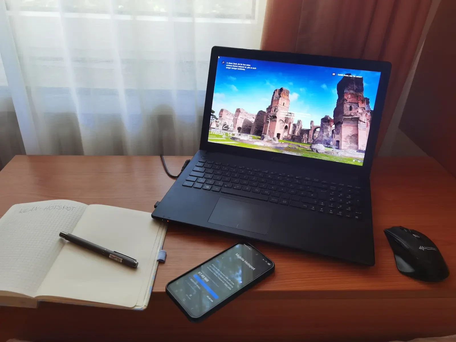 Laptop im Homeoffice mit Smartphone-Hotspot als Ausweichverbindung bei langsamem WLAN