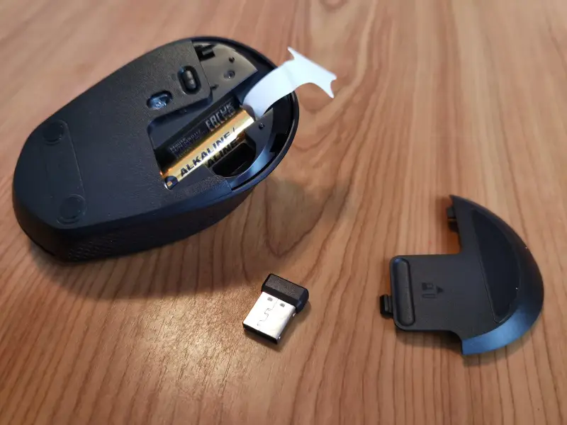 Geöffnetes Batteriefach der Logitech M330 mit AA-Batterie, USB-Empfänger und Abdeckung