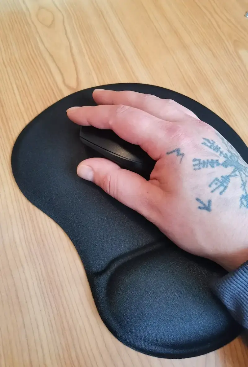 Rechte Hand auf der Logitech M330 auf einem Mauspad mit Handballenauflage