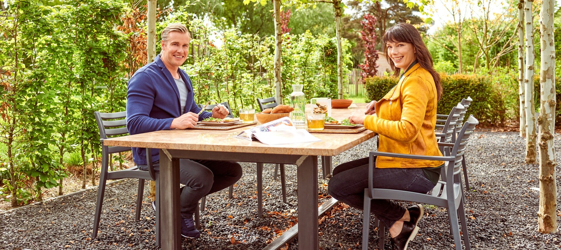 Energieke man en vrouw eten in de tuin