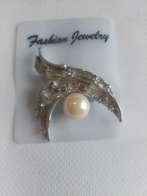 Broche argentée avec perle au centre et quelques strass