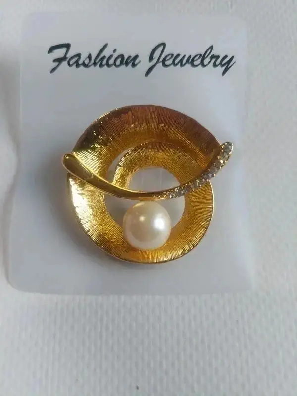 Broche ronde dorée avec perle au centre