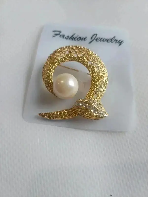 Broche dorée avec perle et feuille en strass
