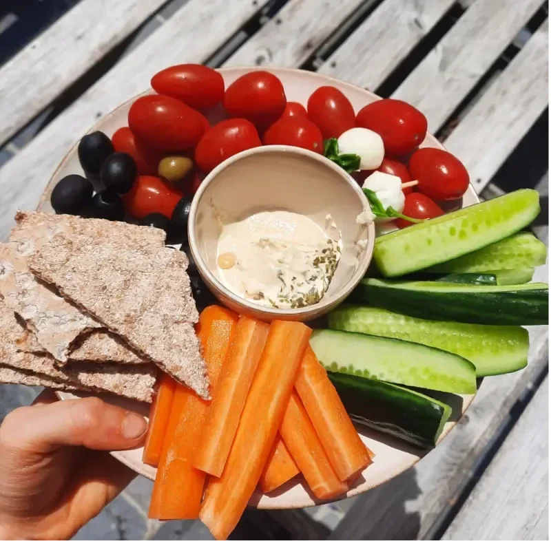 Snackplate met groenten, crackers, olijven en hummus
