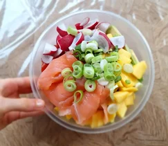 Zomerse poké bowl met zalm, mango, edamame, radijs en avocado, geserveerd in een witte kom met tahin-citroen dressing – gezond, kleurrijk en makkelijk te maken recept.