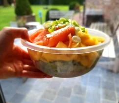 Zomerse poké bowl met zalm, mango, edamame, radijs en avocado, geserveerd in een witte kom met tahin-citroen dressing – gezond, kleurrijk en makkelijk te maken recept.