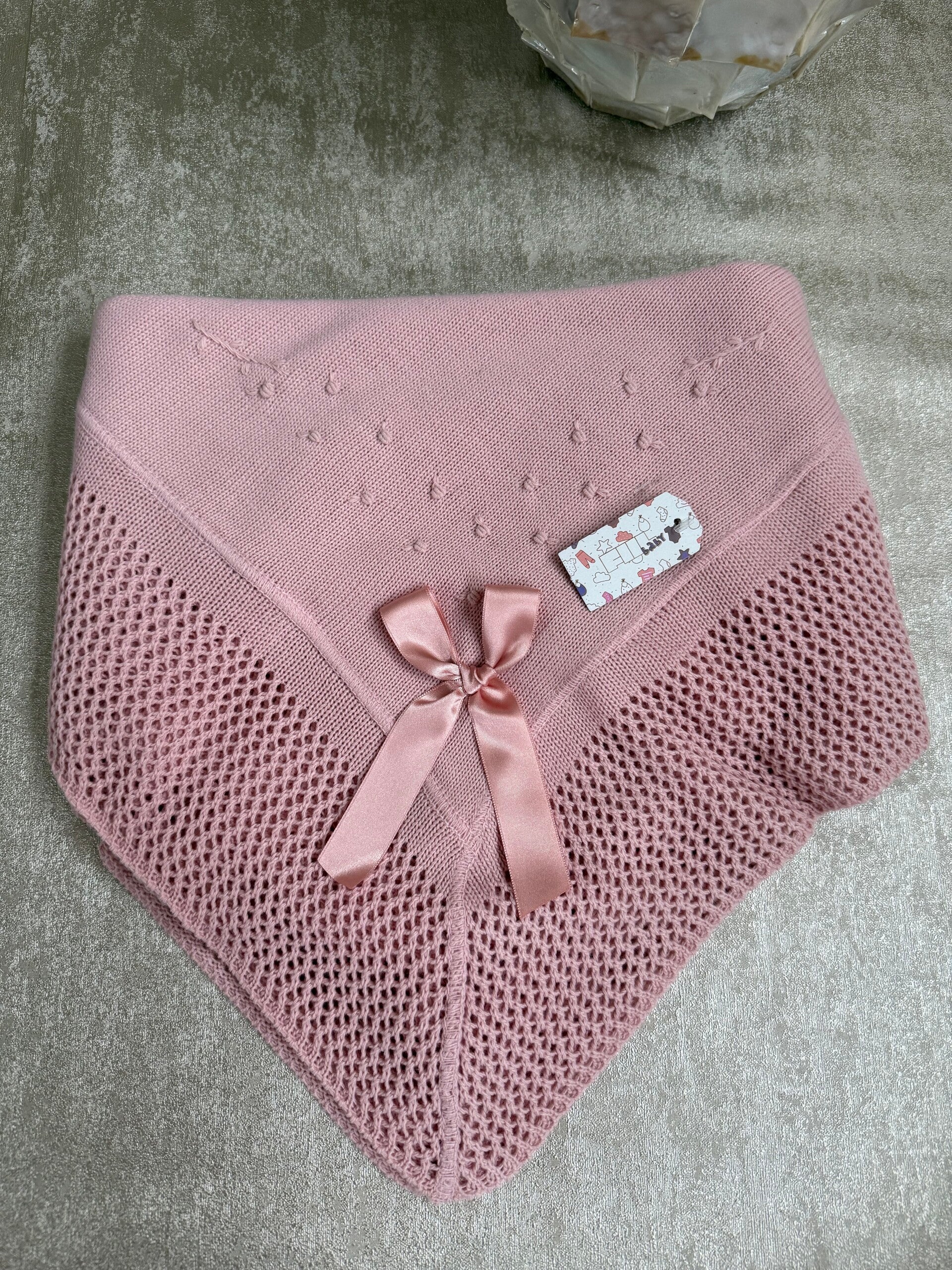 Gebreid dekentje met strik en gaatjes motief