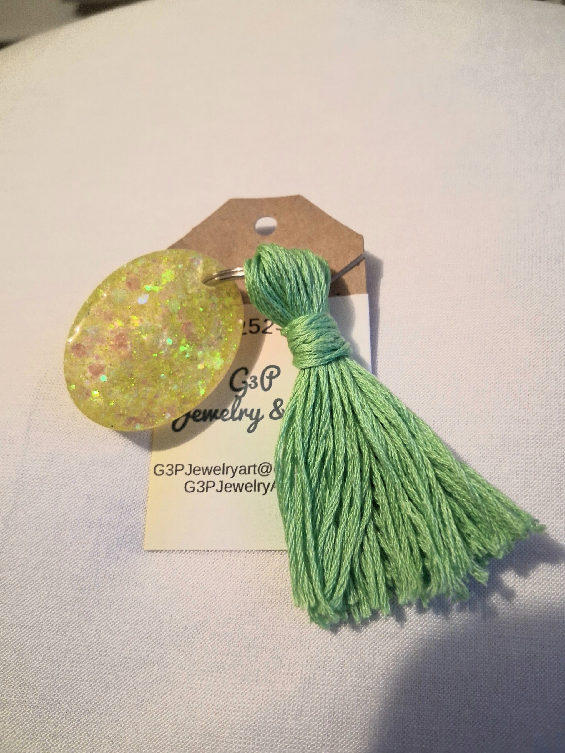 Yellow oval with green tassel keyring