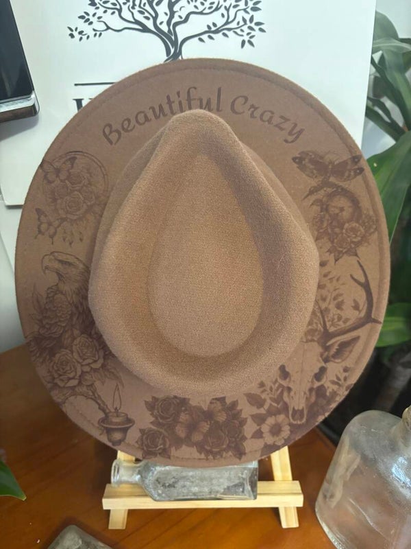 Beautiful Crazy This beautiful fedora hat has been, laser etched, and it has everything beautiful crazy going on with it, dragon flys, eagle, deer scull, butterflies and roses 🥰 can add lacing.