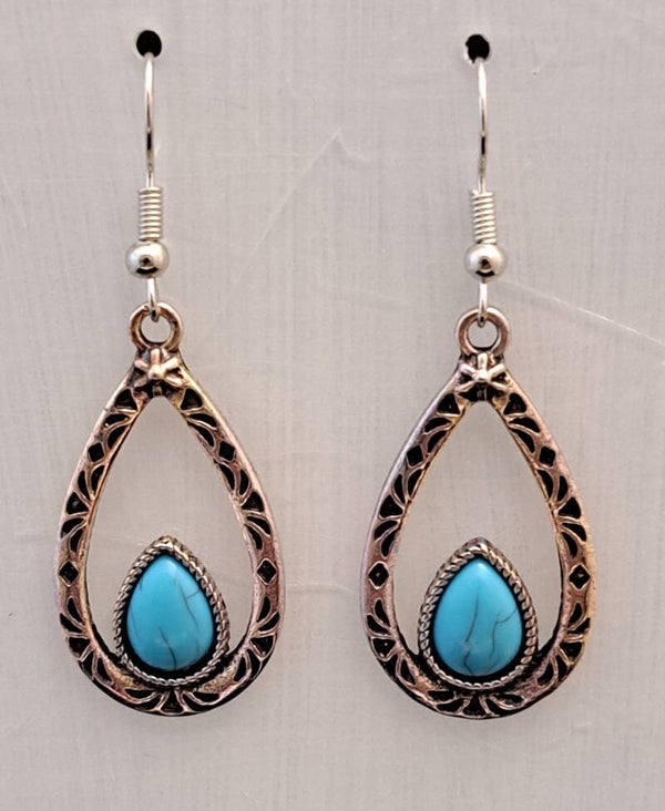 Zilverkleurige bohemian oorbellen in de vorm van een druppel met synthetisch turquoise.