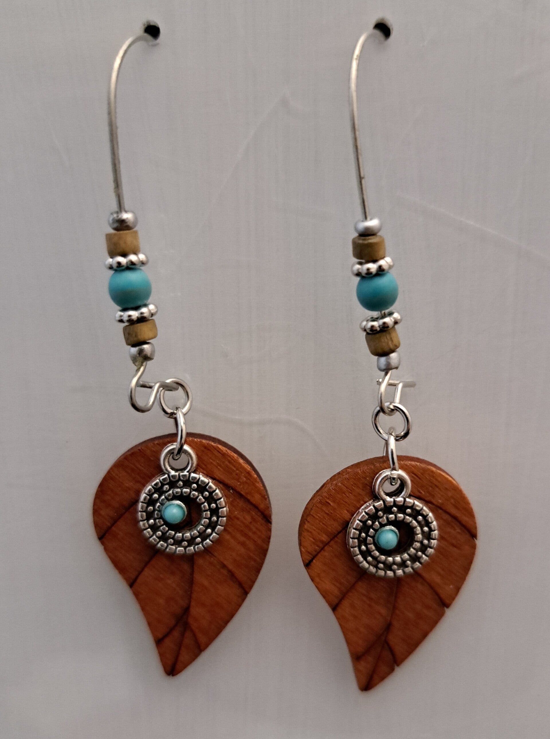 Boho oorbellen met hout blaadje en synthetisch turquoise steentjes.