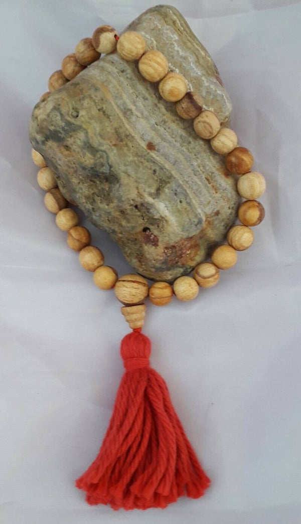 Mala gebeds “armband”van Palo Santo kralen en Guru kraal met rode kwast.