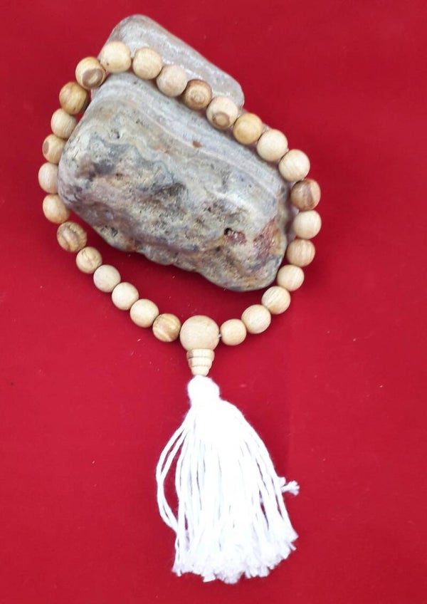 Mala gebeds “armband”van Palo Santo kralen en Guru kraal met witte kwast.
