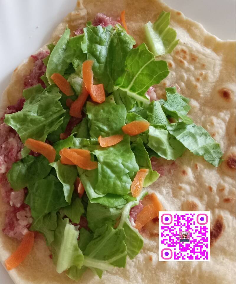 Preparazione di una deliziosa piadina fatta in casa con farcitura di insalata fresca, carote croccanti e altri ingredienti gustosi. Una ricetta semplice e veloce per un pasto sfizioso e nutriente, ideale per un pranzo leggero o una cena veloce. 