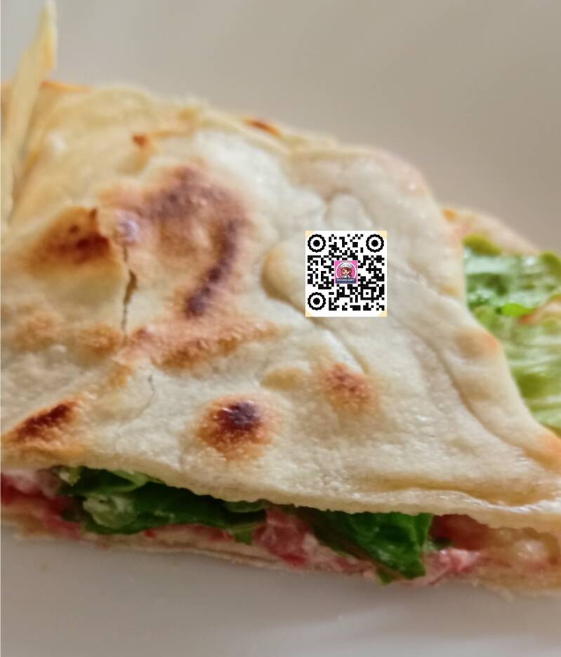 Preparazione di una deliziosa piadina fatta in casa con farcitura di insalata fresca, carote croccanti e altri ingredienti gustosi. Una ricetta semplice e veloce per un pasto sfizioso e nutriente, ideale per un pranzo leggero o una cena veloce. 