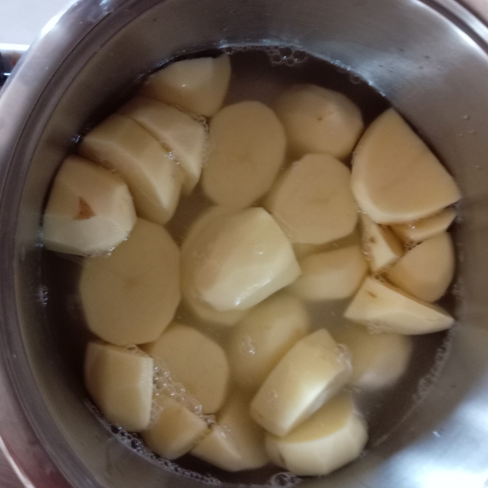Patate messe in una pentola con acqua.